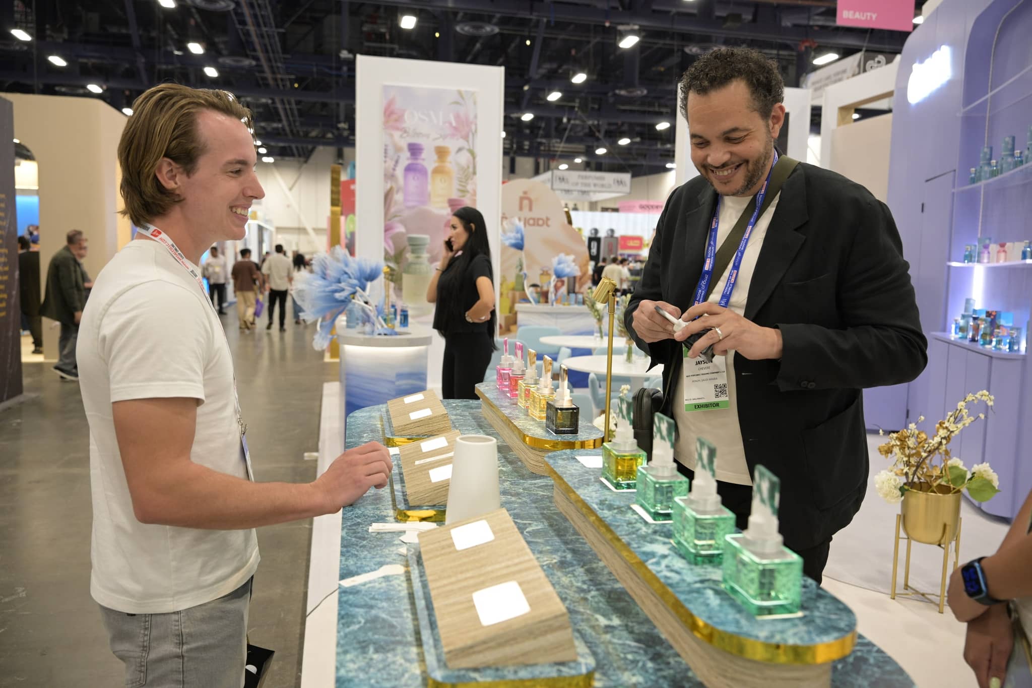 Exhibitor and attendee talking beside a fragrance display