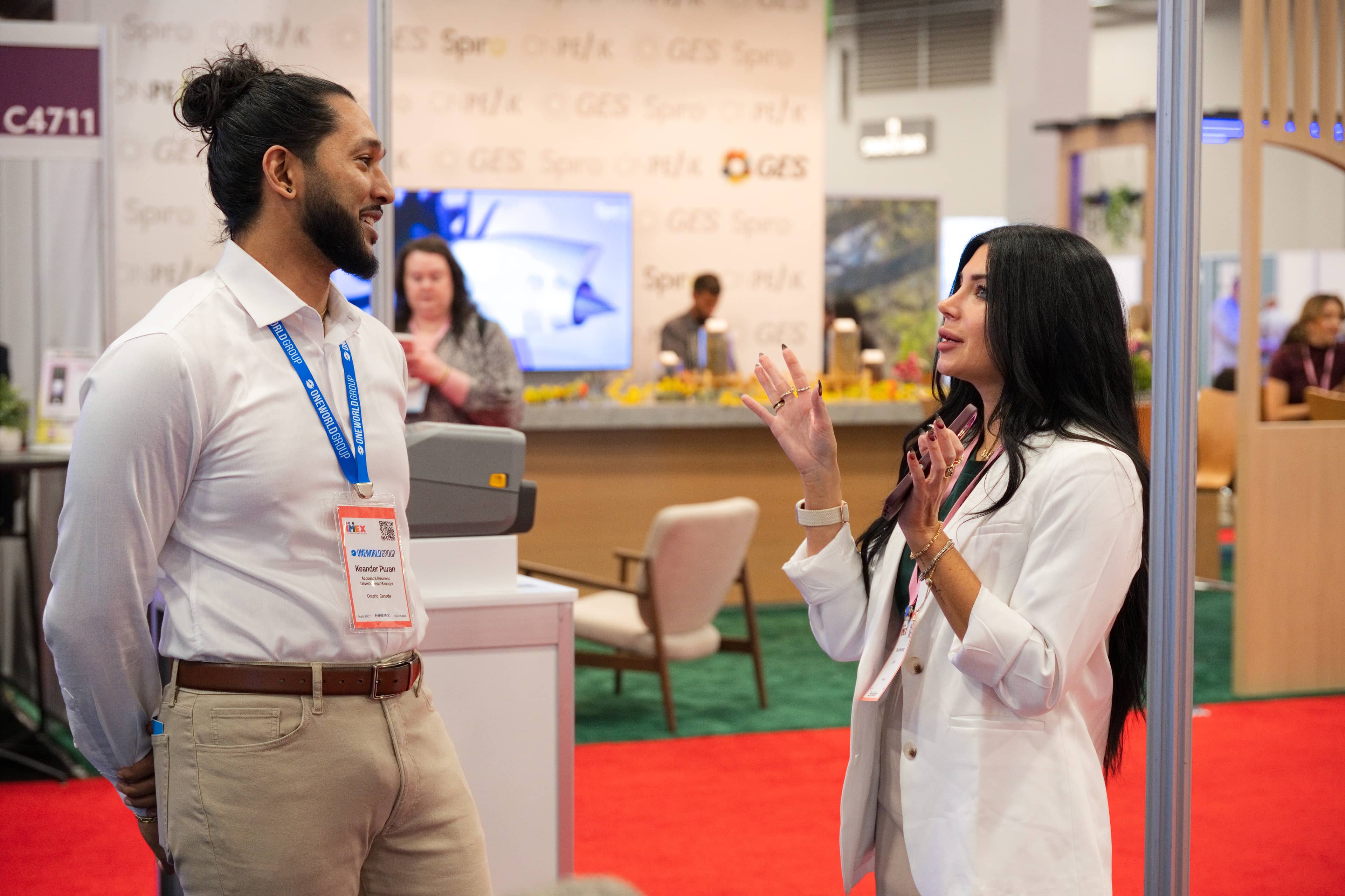 Exhibitor and attendee talking at the One World Group booth